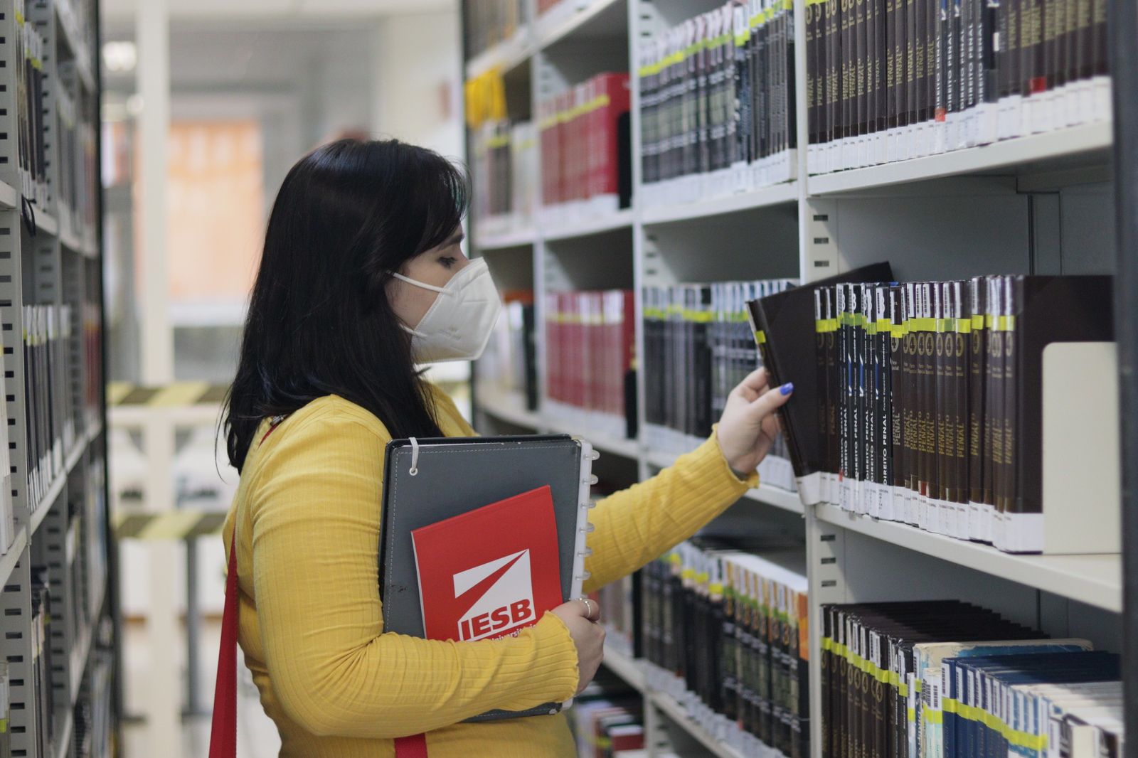 Estudante na biblioteca do IESB